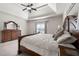 Main bedroom featuring a tray ceiling, ceiling fan, and large bed at 112 Standford Dr, Mcdonough, GA 30252