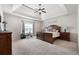 Spacious main bedroom featuring a tray ceiling, ceiling fan, and decorative wall sign at 112 Standford Dr, Mcdonough, GA 30252