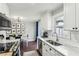 The kitchen features stainless steel appliances and a view of the breakfast area with modern chandelier at 136 Peachtree Memorial Nw Dr # Nj5, Atlanta, GA 30309