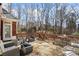 Stone patio deck with wood railing and seating surrounded by mature trees at 7455 Richmond Way, Cumming, GA 30040