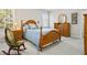 Comfortable bedroom featuring a wooden bed frame, side tables with lamps, and a rocking chair at 7455 Richmond Way, Cumming, GA 30040