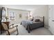 Well-lit bedroom featuring a comfortable iron bed frame, dresser, and a chair with window views at 7455 Richmond Way, Cumming, GA 30040
