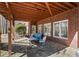 Comfortable covered stone patio with outdoor seating and views of the lush greenery at 7455 Richmond Way, Cumming, GA 30040