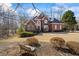 Attractive brick home with a well-kept lawn, mature trees, and a bench to enjoy the peaceful surroundings at 7455 Richmond Way, Cumming, GA 30040
