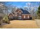 Beautiful brick home featuring a well-manicured lawn and professional landscaping at 7455 Richmond Way, Cumming, GA 30040