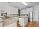 Bright kitchen featuring granite countertops, stainless steel appliances, an island, and hardwood floors at 7455 Richmond Way, Cumming, GA 30040