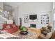 Open-concept living room with a fireplace, built-in shelving, hardwood flooring, and a staircase at 7455 Richmond Way, Cumming, GA 30040