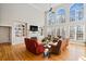 Bright living room with high ceilings, built-in shelving, large windows, fireplace, and hardwood flooring at 7455 Richmond Way, Cumming, GA 30040