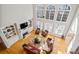 Sun-filled living room featuring high ceilings, large windows, hardwood floors, fireplace, and built-in bookshelves at 7455 Richmond Way, Cumming, GA 30040