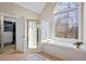 Bathroom features soaking tub, shower with glass door, and decorative window at 7455 Richmond Way, Cumming, GA 30040