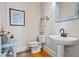 Charming powder room with hardwood floors features a decorative mirror and pedestal sink at 7455 Richmond Way, Cumming, GA 30040