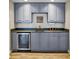 Custom wet bar featuring blue cabinetry, granite countertops, and a mini-fridge at 7455 Richmond Way, Cumming, GA 30040