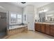 Bright bathroom featuring a soaking tub, a glass shower, and a vanity with wood cabinets at 2061 Westwood Cir, Smyrna, GA 30080