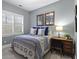 Comfortable bedroom featuring a patterned comforter, window with plantation shutters, and a desk at 2061 Westwood Cir, Smyrna, GA 30080