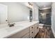 Bathroom featuring double sink vanity with granite counters, a tile shower and wood look flooring at 210 Joe Green Ln, Canton, GA 30114