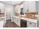 This kitchen features white cabinets, stainless steel appliances, brick backsplash and wood flooring at 210 Joe Green Ln, Canton, GA 30114