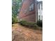 Side view of a brick townhome featuring mature trees and a well-manicured lawn at 3851 Guilderoy Ln # 1, Austell, GA 30106