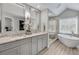 Bathroom featuring double sink vanity, granite counters, framed mirrors, soaking tub and glass shower at 4000 Rockingham Dr, Roswell, GA 30075