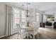 Bright dining area with a round table, modern light fixture, and view towards the living room area at 4000 Rockingham Dr, Roswell, GA 30075