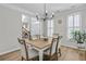 Bright dining room with hardwood floors, modern chandelier, and large windows with plantation shutters at 4000 Rockingham Dr, Roswell, GA 30075