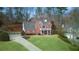 A stately brick home boasts a covered porch and a meticulously maintained front yard at 4000 Rockingham Dr, Roswell, GA 30075