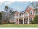 Charming brick home featuring a covered porch and lush green lawn at 4000 Rockingham Dr, Roswell, GA 30075