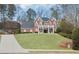 Traditional two-story brick home featuring a charming front porch and lush lawn at 4000 Rockingham Dr, Roswell, GA 30075