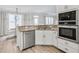 Modern kitchen featuring granite countertops, stainless steel appliances, and white cabinetry, bathed in natural light at 4000 Rockingham Dr, Roswell, GA 30075