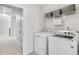 Laundry room featuring new washer and dryer, wire rack shelving, and doorway leading to the hallway at 4000 Rockingham Dr, Roswell, GA 30075