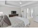 Comfortable primary bedroom showcasing a tray ceiling, plush carpet, and an ensuite bathroom, perfect for relaxation at 4000 Rockingham Dr, Roswell, GA 30075