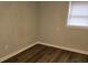 This bedroom features wood flooring, a window with blinds, and neutral colored walls at 5709 Lee St, Morrow, GA 30260