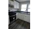 This kitchen features stainless steel appliances, bright white cabinetry, and a dual-basin sink at 5709 Lee St, Morrow, GA 30260