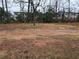 View of a partially cleared lot with multiple residences in the background at 5709 Lee St, Morrow, GA 30260