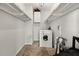 Small laundry room with washer, dryer, shelving, and cleaning supplies at 6851 Roswell Rd # F32, Sandy Springs, GA 30328