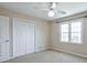 Well-lit bedroom with a double closet, large window, and neutral carpeting at 893 Lance Cir, Lawrenceville, GA 30043