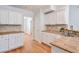 Bright kitchen with tile backsplash, hardwood floors, and white cabinetry at 893 Lance Cir, Lawrenceville, GA 30043