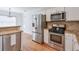 Modern kitchen featuring stainless steel appliances, white cabinets, and a breakfast bar at 893 Lance Cir, Lawrenceville, GA 30043