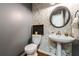 Charming powder room with decorative wallpaper, pedestal sink, modern fixtures, and wood look flooring at 108 Ardsley Run, Canton, GA 30115