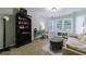 Relaxing sitting room with carpet, white sofa, a bookshelf, and natural light at 108 Ardsley Run, Canton, GA 30115