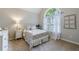 Cozy bedroom showcasing a decorative window, bed, and matching nightstand at 108 Ardsley Run, Canton, GA 30115