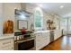 Beautiful renovated kitchen with stainless steel appliances, white cabinets, marble countertops, and farmhouse sink at 108 Ardsley Run, Canton, GA 30115