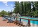 Community pool with a wooden deck, blue lounge chairs and umbrellas, and mature trees in the background at 1322 Stanley Park Dr, Decatur, GA 30033