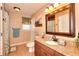 Bathroom with a granite countertop vanity, a patterned window, and a decorative mirror at 3064 Zermatt Way, Snellville, GA 30078