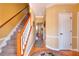 Hallway with wooden floor, carpeted stairs and open access to other rooms at 3064 Zermatt Way, Snellville, GA 30078