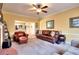 Comfortable living room featuring a ceiling fan, large leather sofa, and an open view to the kitchen at 3064 Zermatt Way, Snellville, GA 30078