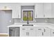 Contemporary kitchen with sleek white cabinets, stainless steel dishwasher, and a modern backsplash at 6684 Heathrow Ln, Stone Mountain, GA 30087