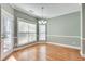 Bright dining room featuring hardwood floors, a modern light fixture, and large windows with wooded views at 2477 Misty Rose Ln, Loganville, GA 30052