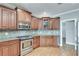 Well-lit kitchen featuring stainless steel appliances, gas range, and wooden cabinetry at 2477 Misty Rose Ln, Loganville, GA 30052