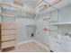 Well-organized laundry room equipped with custom shelving, drawers, a utility sink, and neutral tile flooring at 2477 Misty Rose Ln, Loganville, GA 30052