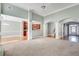 Open living room with a view to the kitchen and stairwell, featuring neutral carpet and bright paint at 2477 Misty Rose Ln, Loganville, GA 30052